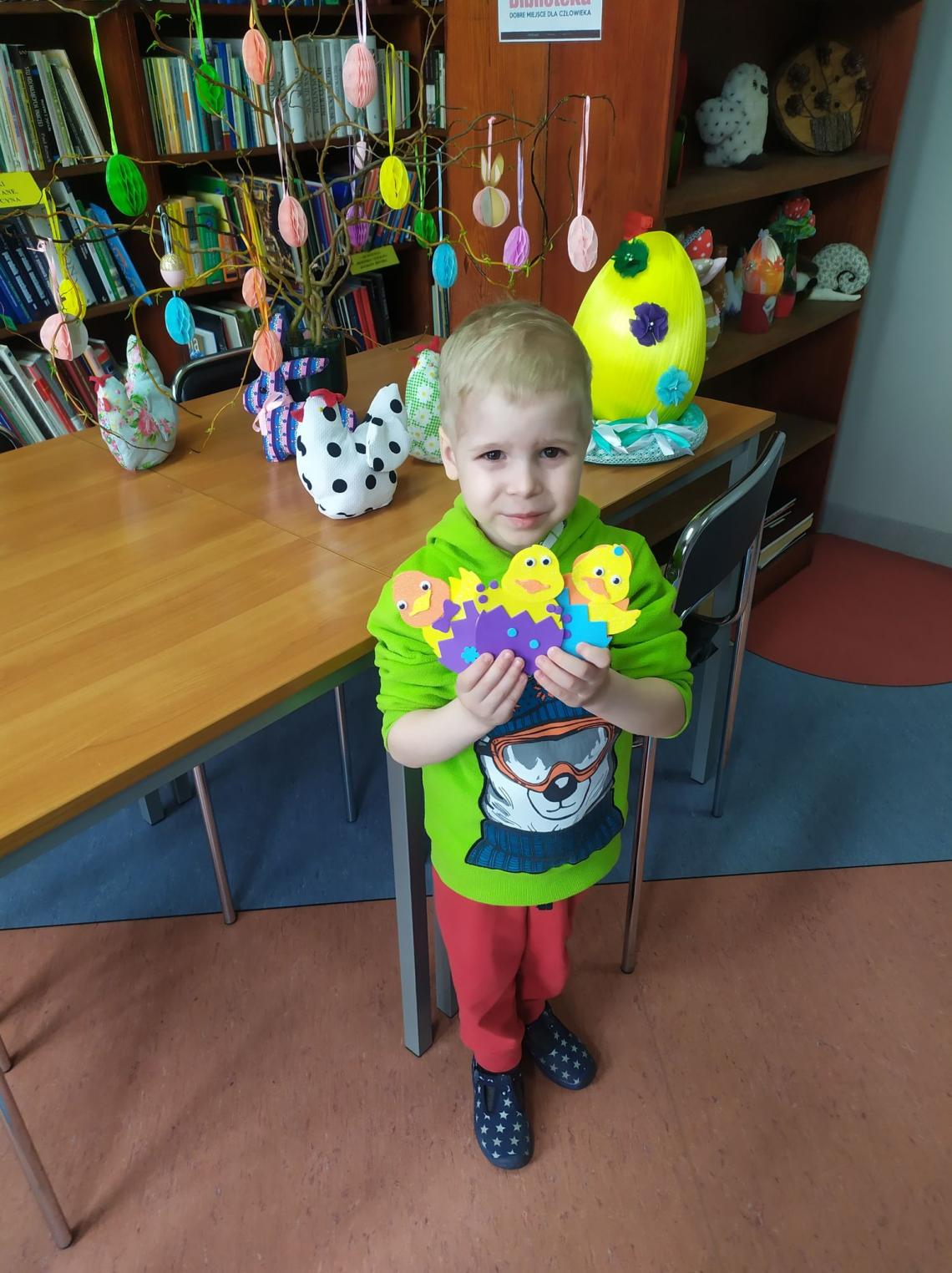 Uczestnik warsztatów wielkanocnych w bibliotekach na terenie Gminy Białogard z wykonaną własnoręcznie ozdobą wielkanocną